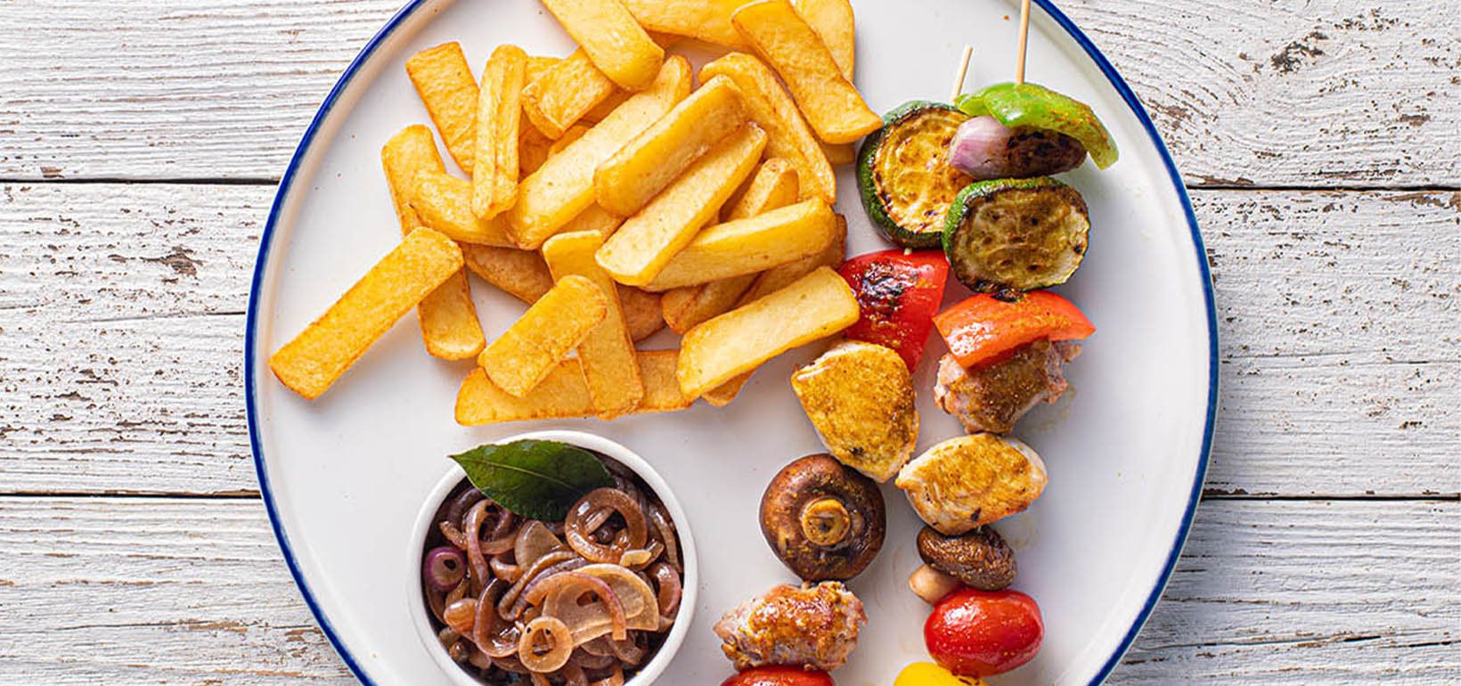 Saslik csirkéből salsiccia kolbásszal, zöldséggel, karamellizált hagymával és a Steak Fries hasábburgonyával